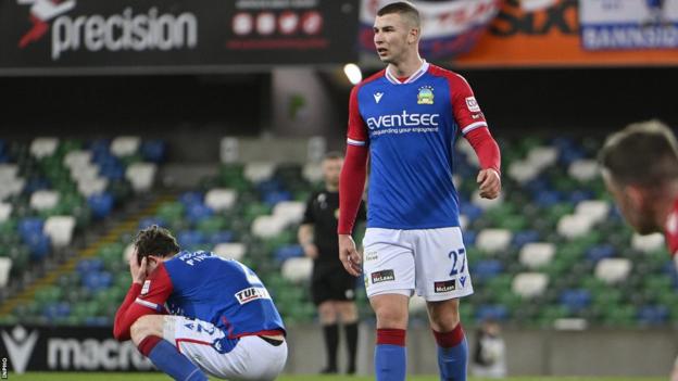 Daniel Finlayson (left) and Ethan McGee show their disappointment after the final whistle at Windsor Park