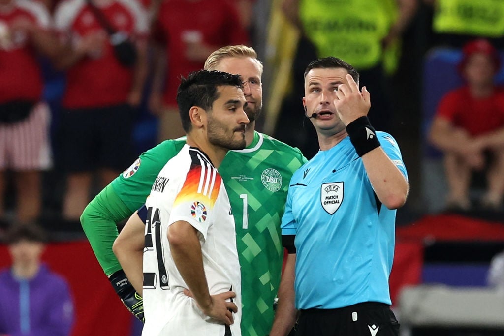Referee Michael Oliver, Ilkay Guendogan of Germany and Kasper Schmeichel of Denmark look up into the sky in anticipation of a person on the stadium roof during the UEFA EURO 2024 round of 16 match between Germany and Denmark at Football Stadium Dortmund on 29 June 2024 in Dortmund, Germany. (Alexander Hassenstein/Getty Images)